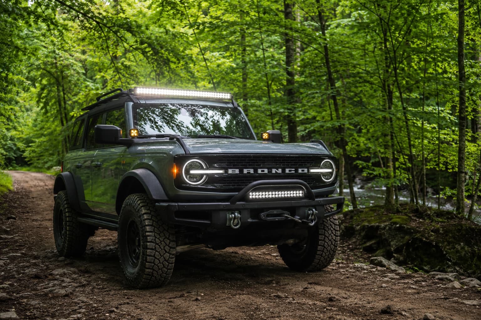 Bronco lit by full lighting kit in bright forest setting